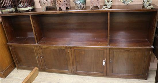 A mahogany low bookcase, fitted adjustable shelving over cupboards W.241cm